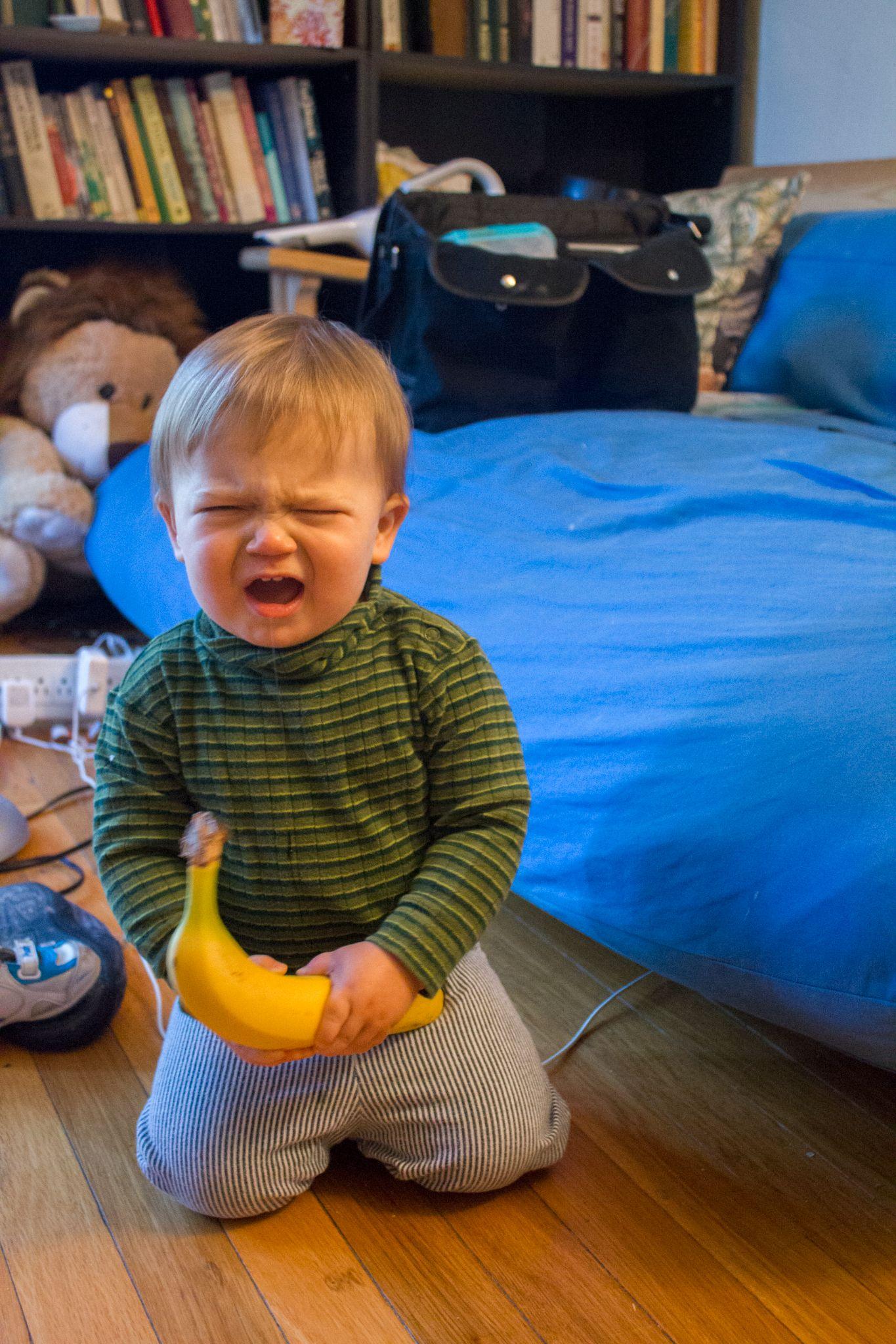 Crying toddler with banana.