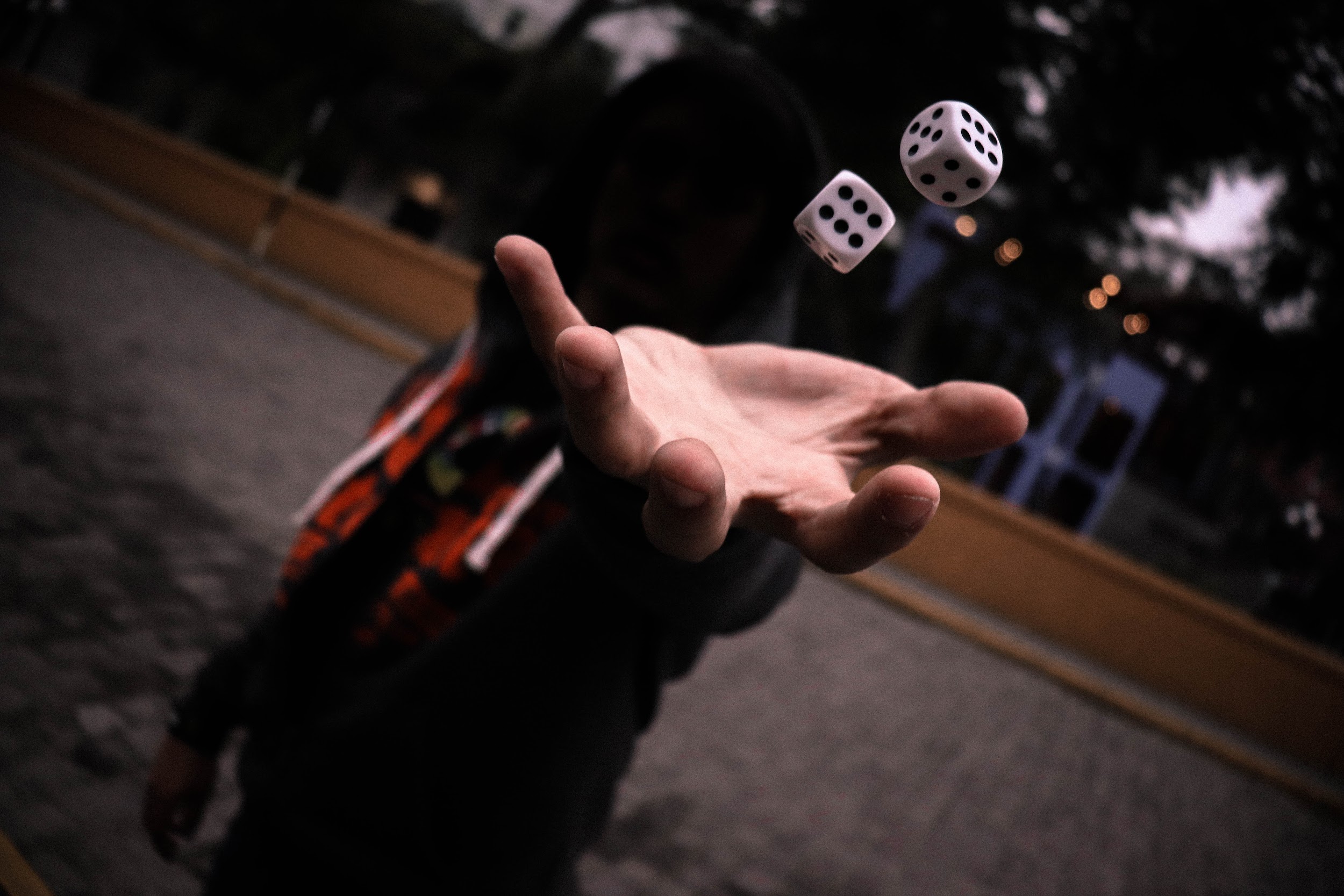 A person throwing dice from their left hand.