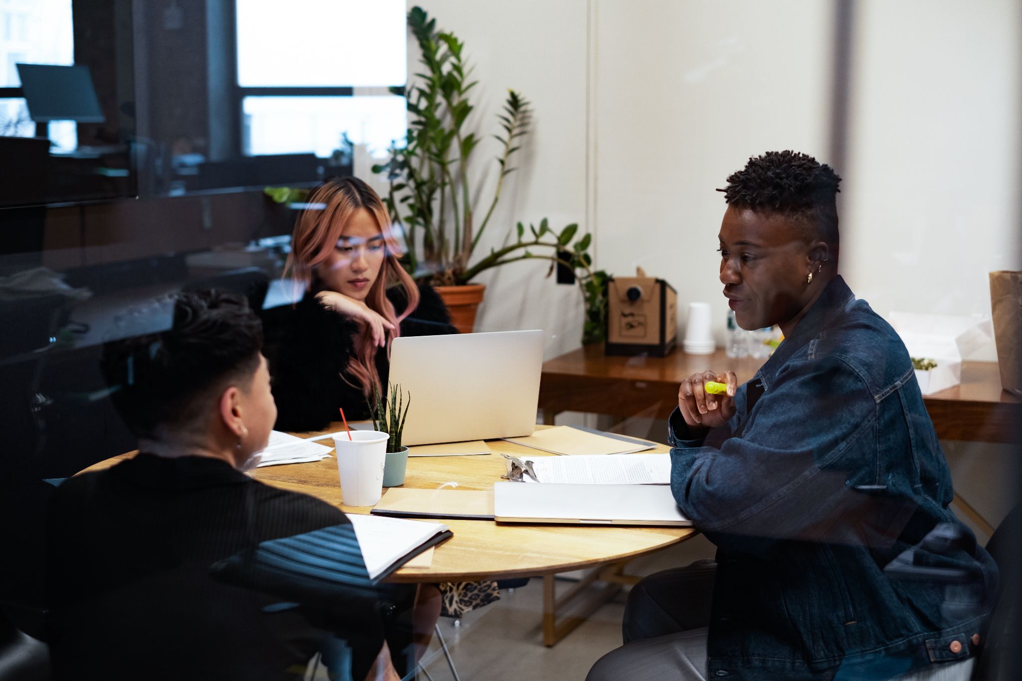 A group of people having a meeting around a round table.