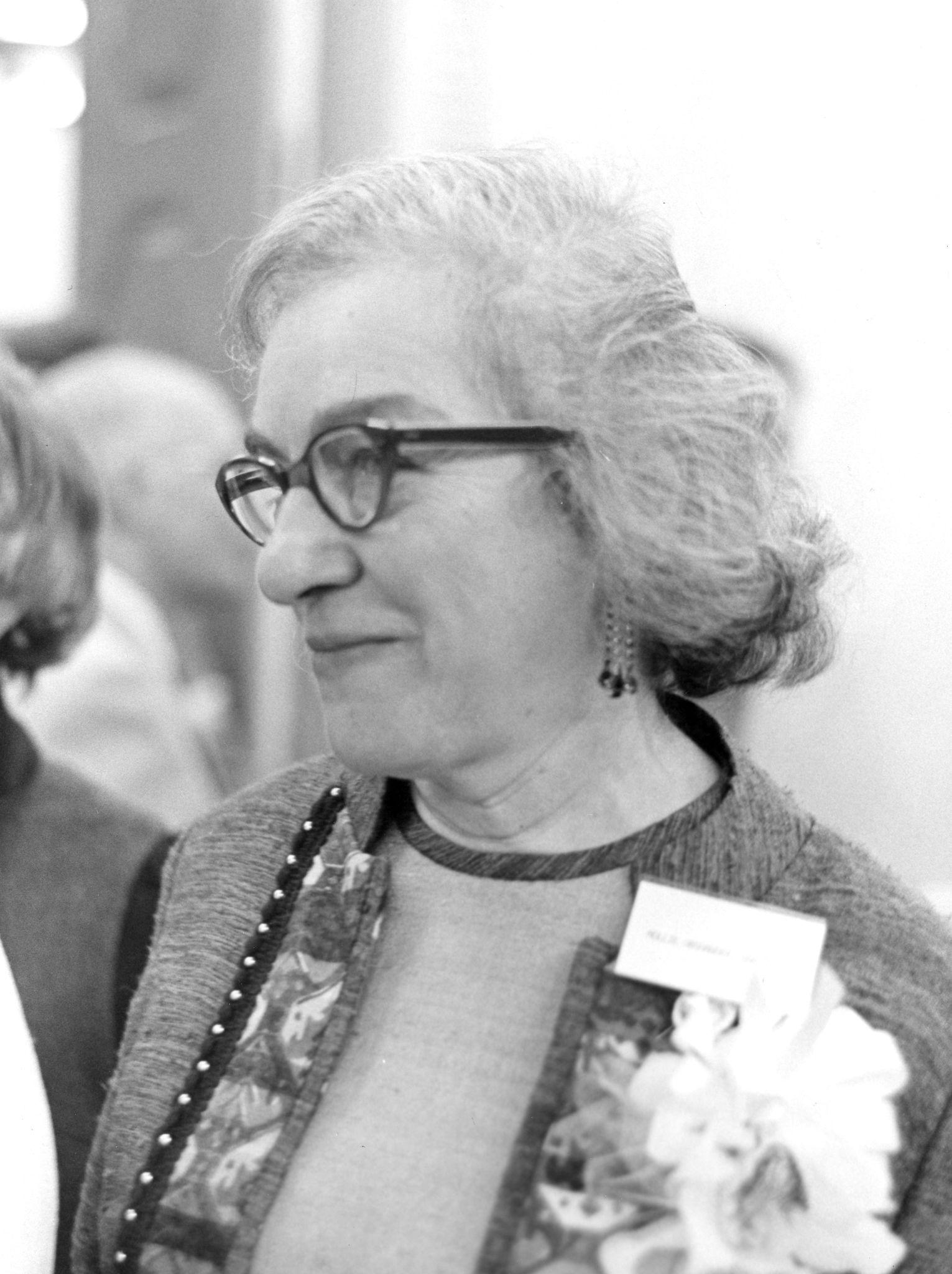 Photo of Mollie Orshansky wearing glasses and looking to the left.