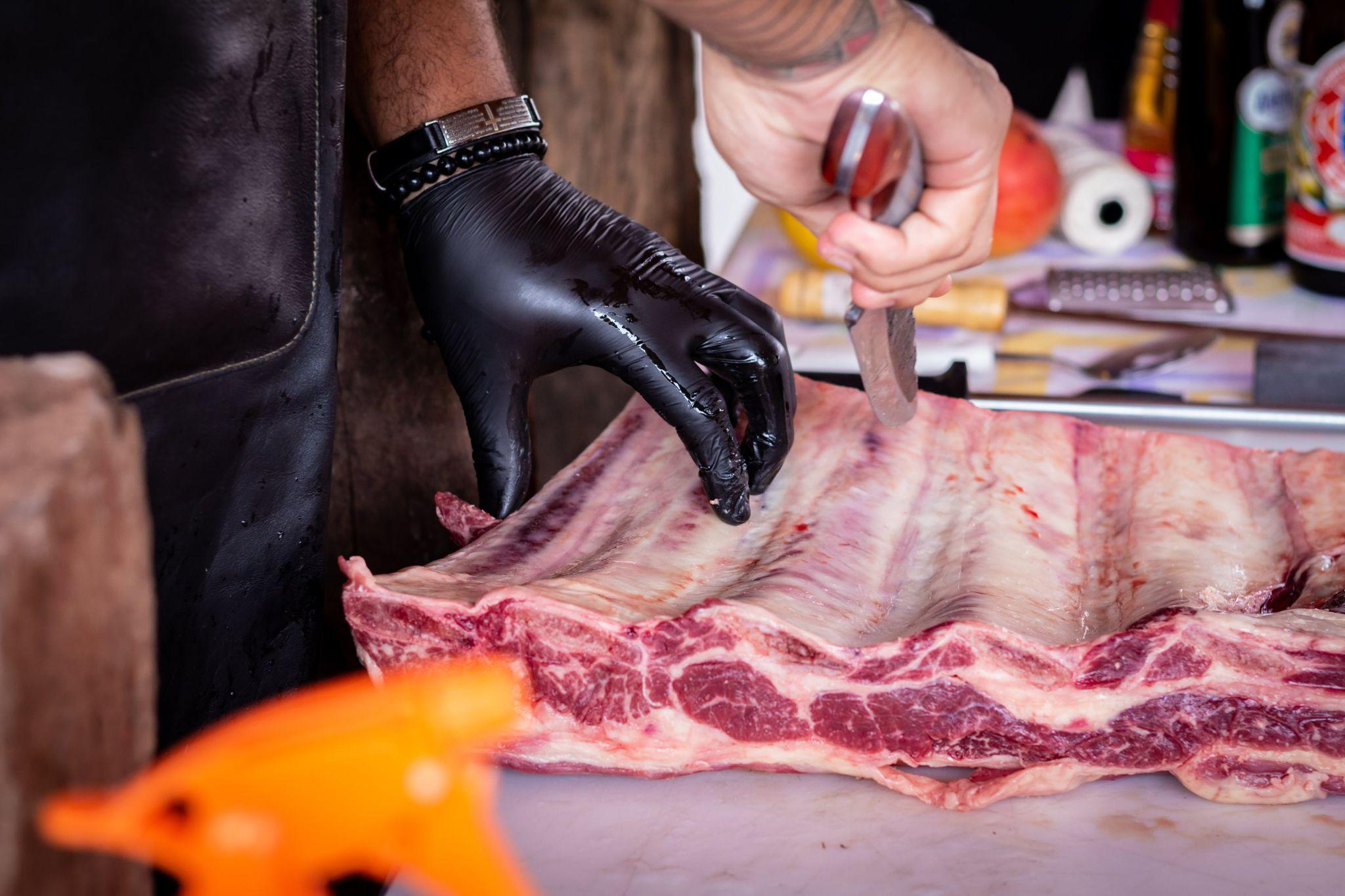 Butcher cutting a rack of ribs.