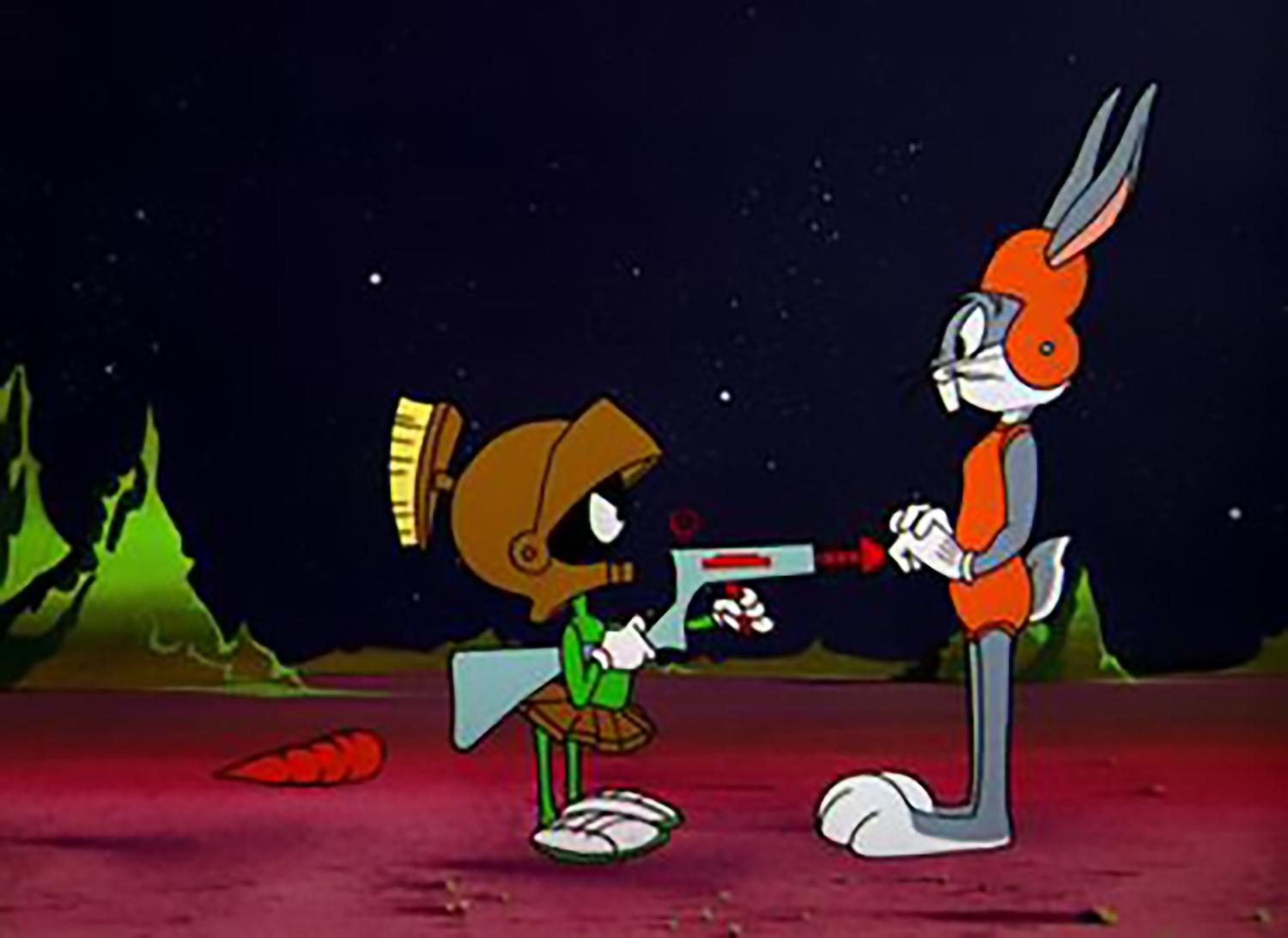 Marvin the Martian points a raygun at Bugs Bunny while they are standing on the surface of Mars.