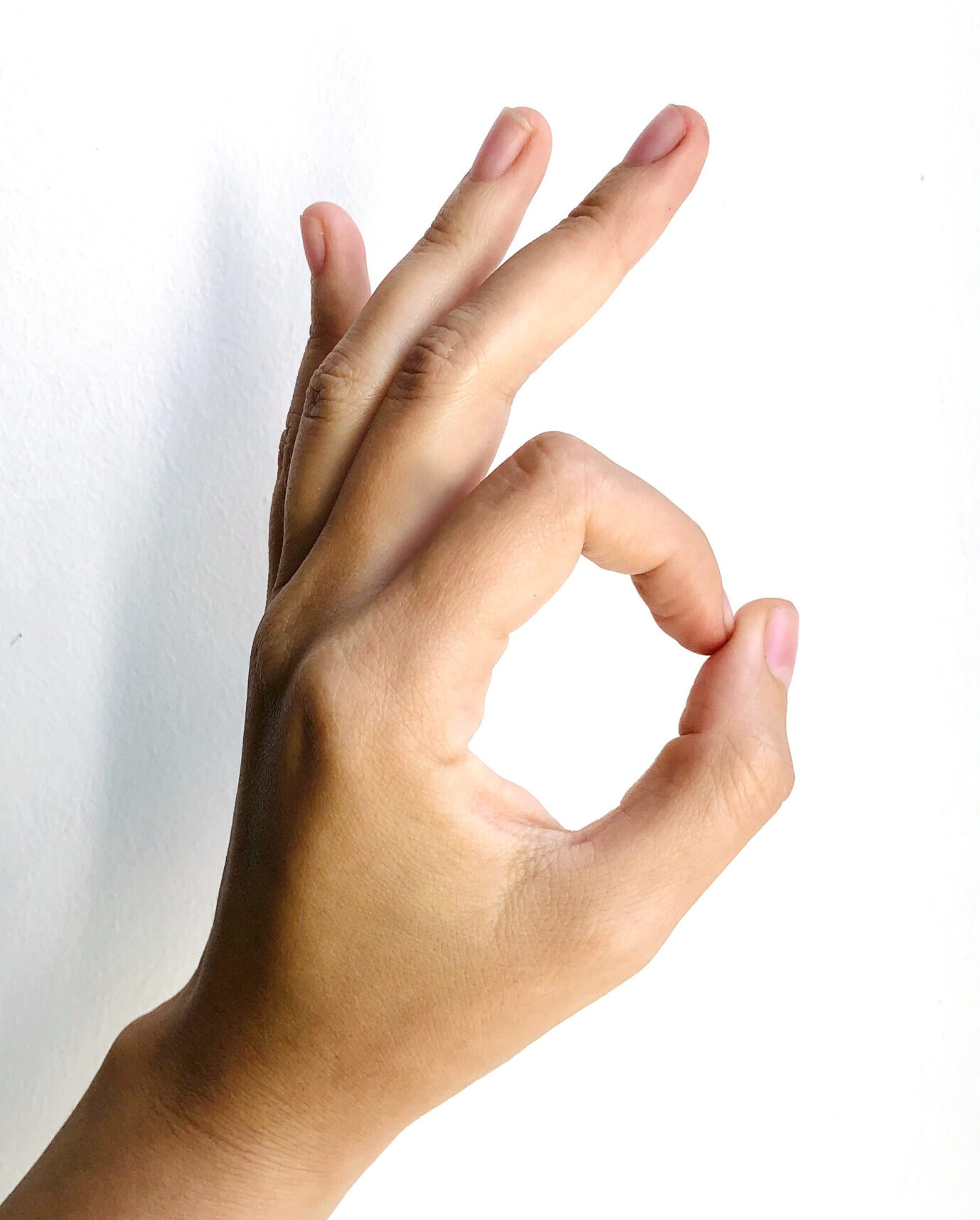 Hand making "OK" gesture.