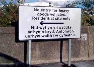 Picture of a road sign in Wales that reads: Nid wyf yn y swyddfa ar hun o bryd. Anfonwch unrhyw wait i'w gyfieithu"I am not in the office at the moment. Send any work to be translated"