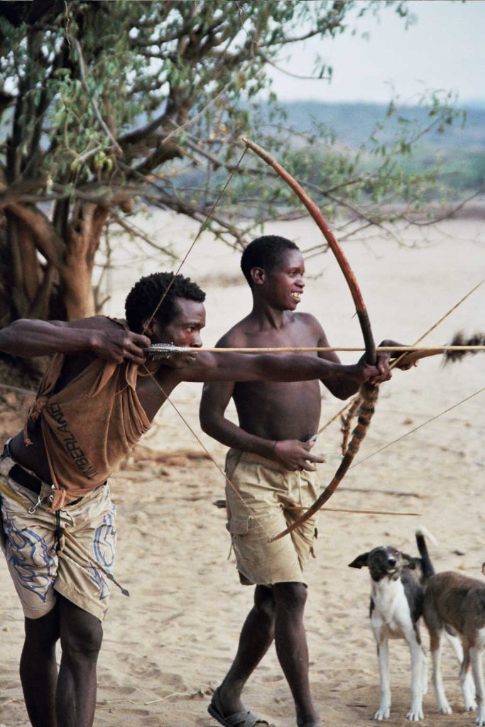 A photo of Hadzabe men practicing bowing