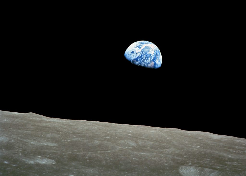 Photo of a distant Earth, half shrouded in shadow, from the moon