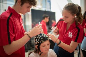 Research assistants applying an EEG cap to a teen.