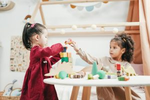 Two girls playing with blocks at a table