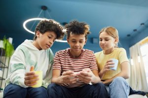 A group of kids looking at a cellphone