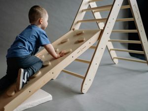 A child playing on a wooden climbing frame