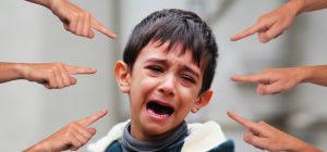 A child crying with 6 fingers pointing at him.