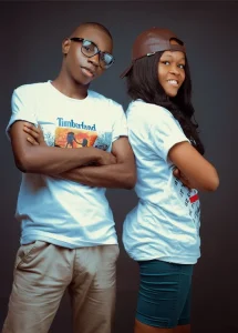 Adolescents standing back to back, smiling with their arms crossed.