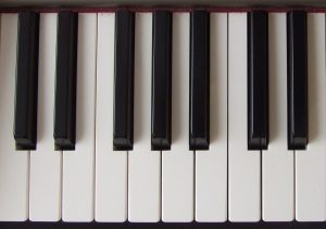 A photograph of a piano keyboard. There are both white keys and black keys. 