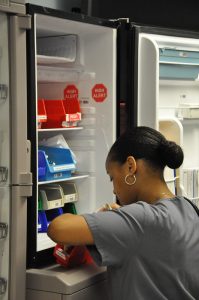 African American nurse retrieving medication.