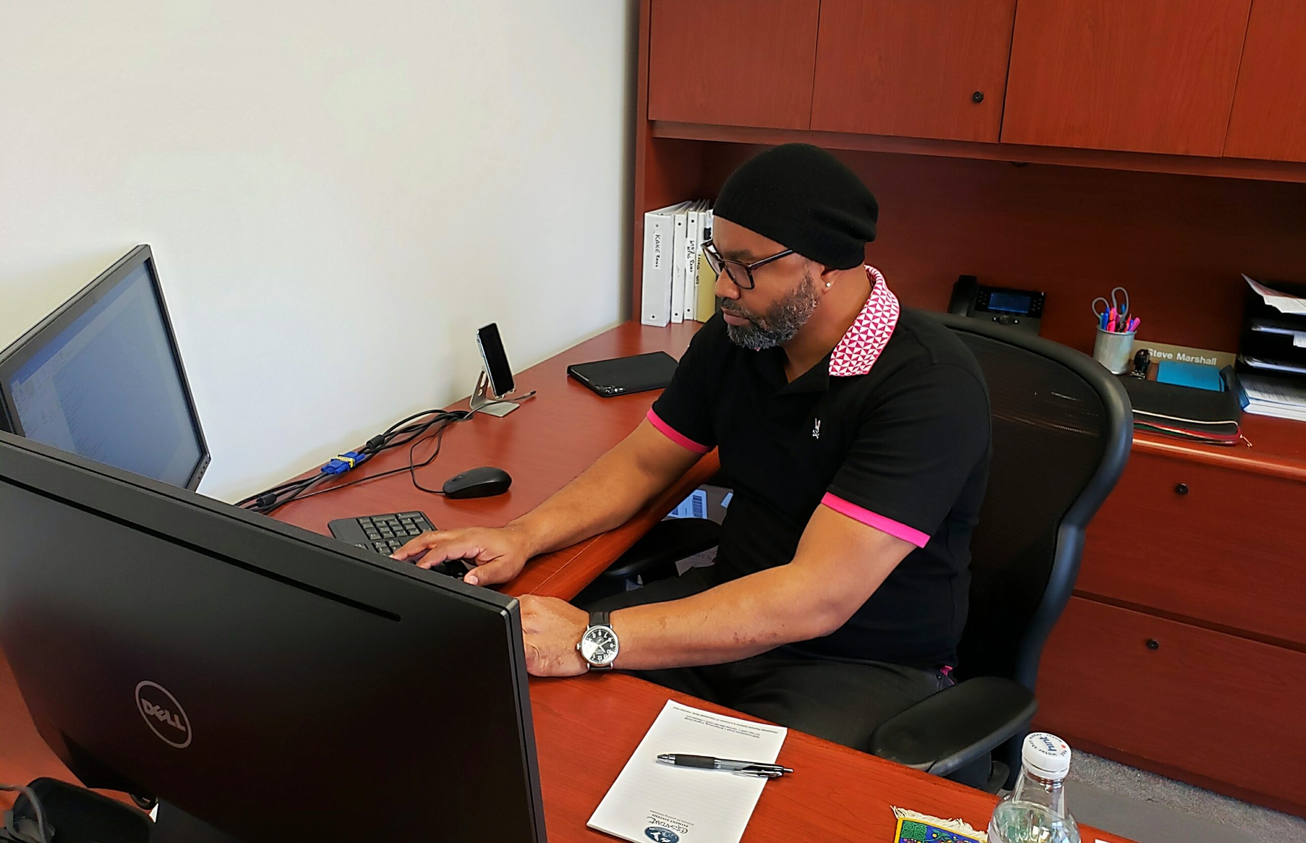 Man seated at desk typing on computer