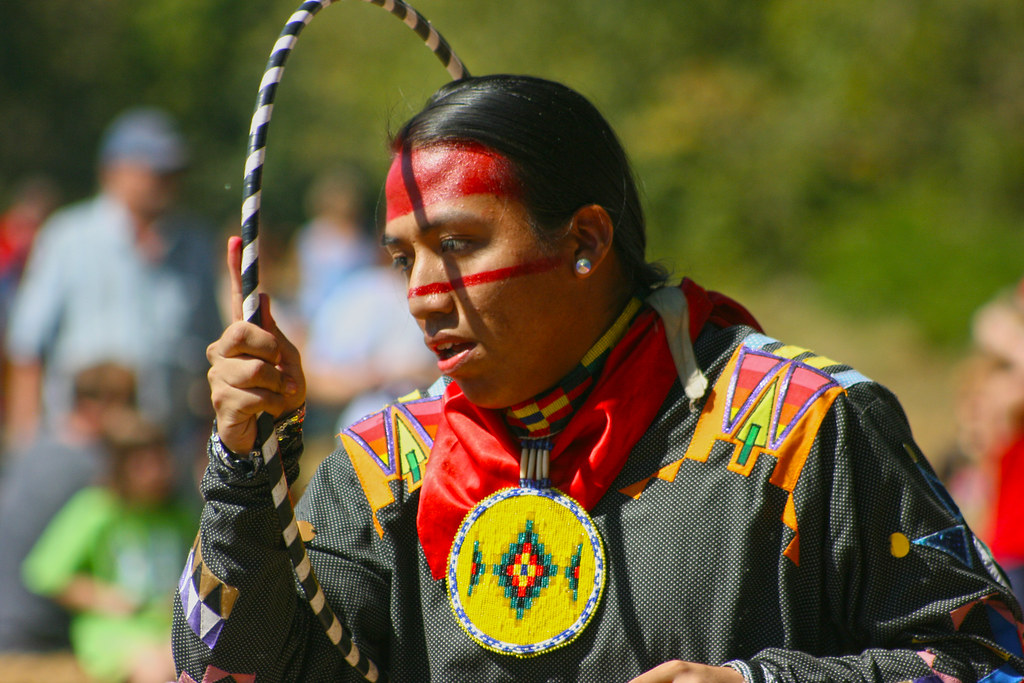 Native American man dressed in traditional clothing participating in a cultural celebration
