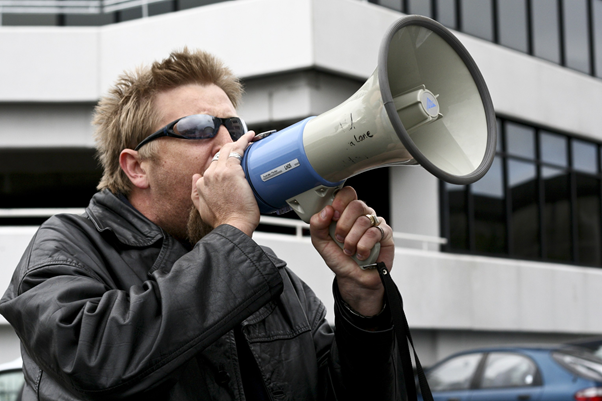 Photo of a man shouting through a megaphone