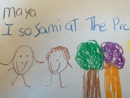 Child's writing has the name "Maya" in the top left corner. A sentence written with some correct spelling and some invented spelling is underneath "Maya." Two children and two trees are drawn across the bottom half of the paper.