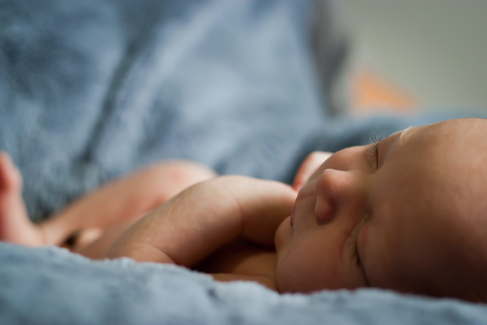 photo of very young baby sleeping on a blanket