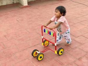 small child pushing a walking toy