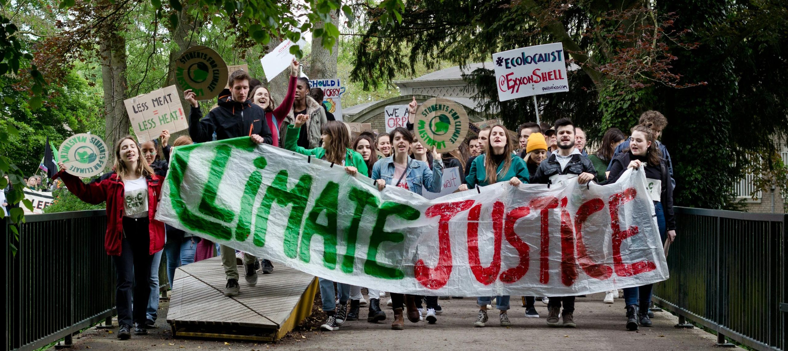 People holding a banner that says "Climate Justice"